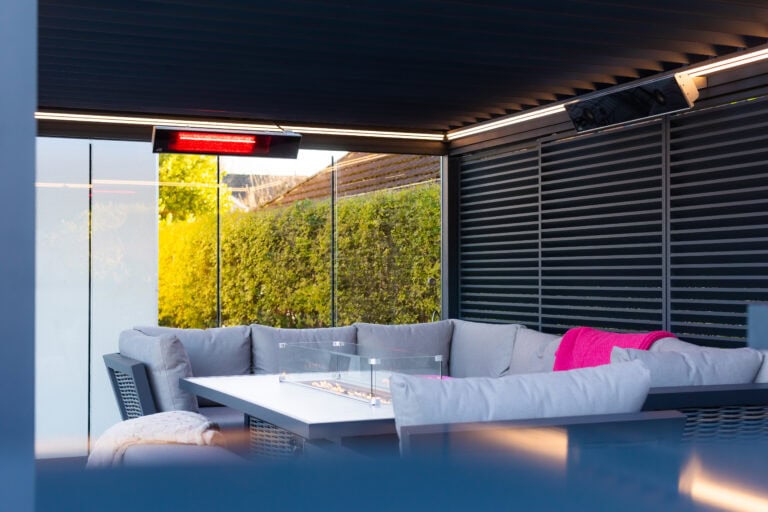 Detail of a pergola side blind and glass screen with an infrared heater mounted above