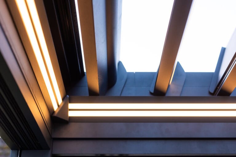 Close-up of integrated LED lighting along a pergola aluminium roof beam and support post