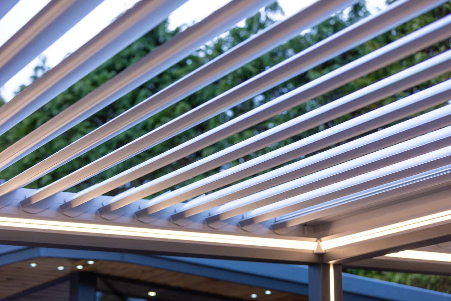 Aluminium louvre roof pergola slats shown open against an evening sky, with integrated lighting