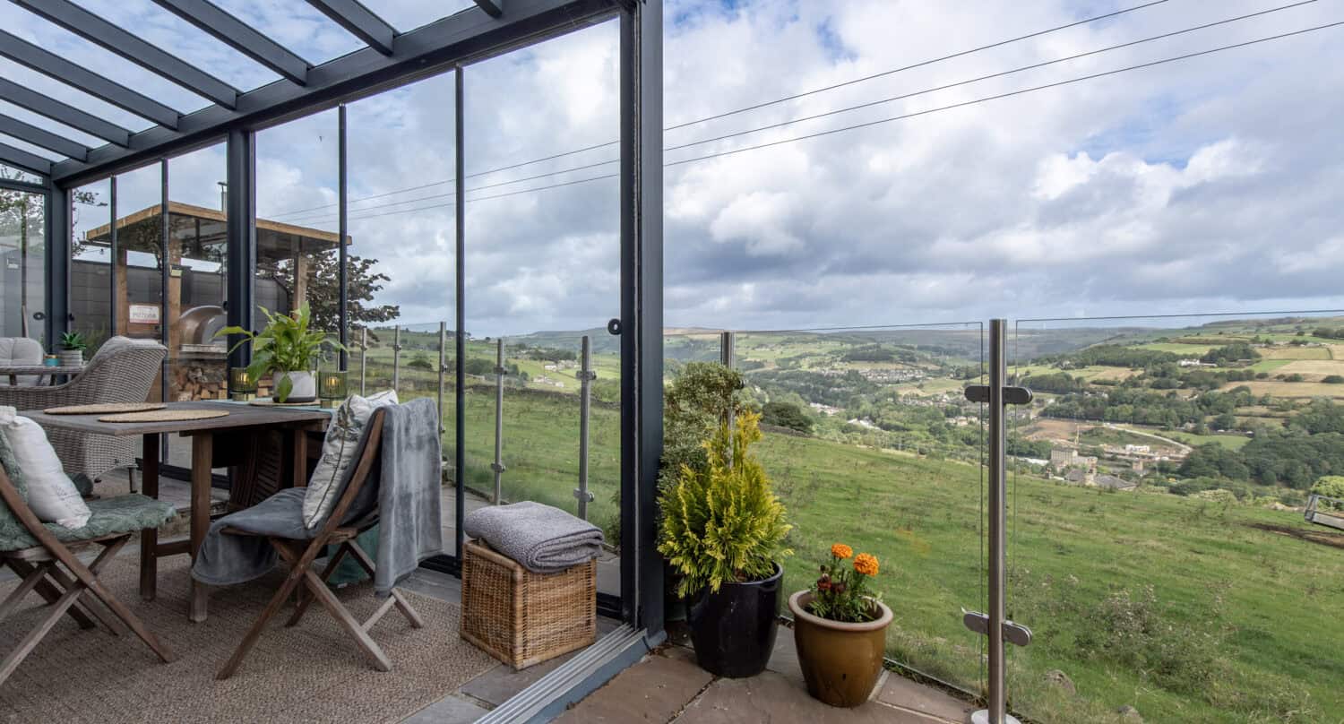 Bespoke glass veranda with sliding glass doors and panoramic countryside views