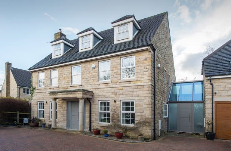 Luxury home featuring white windows and a clear grey front door with side panels