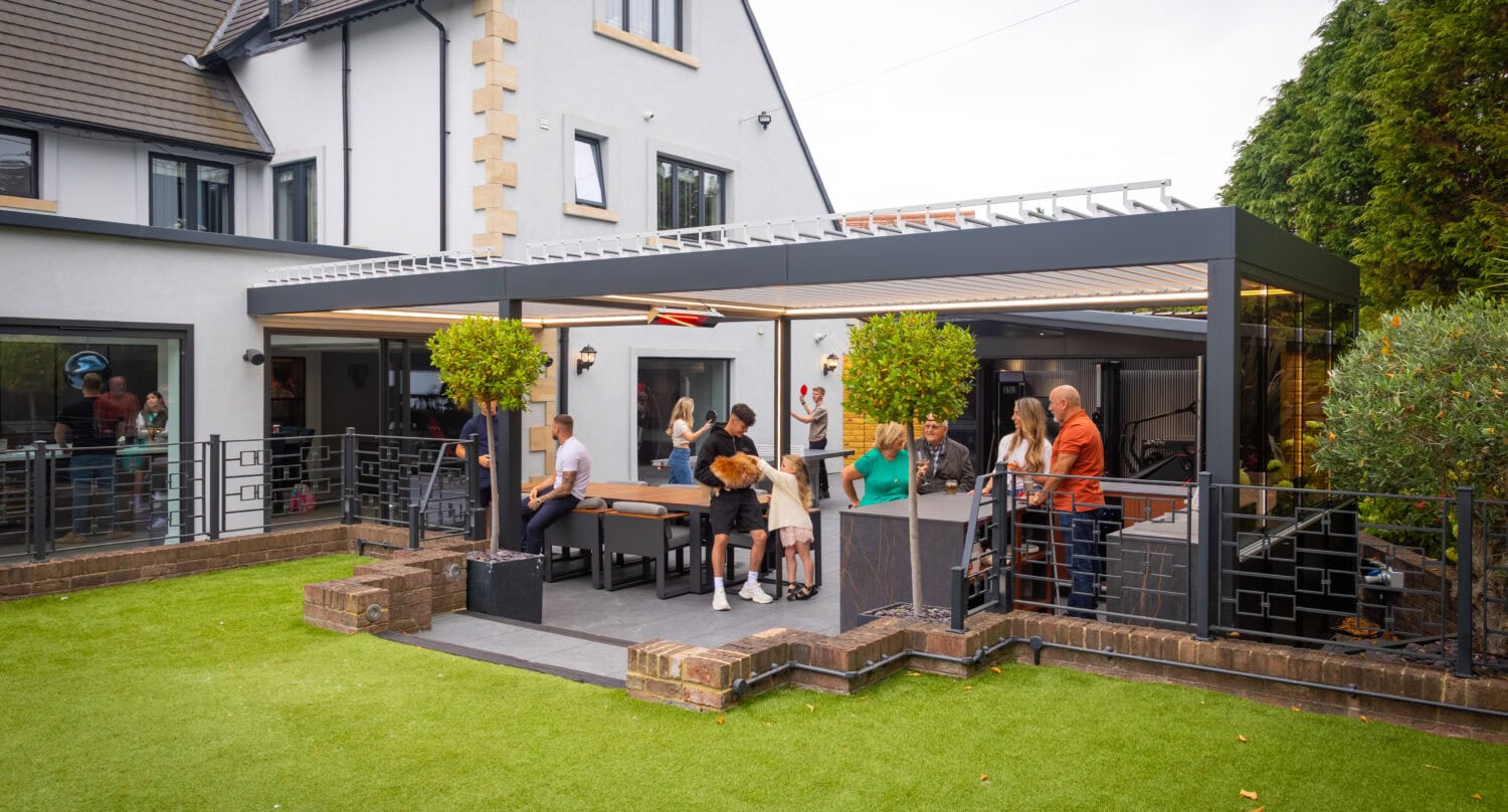 Aluminium pergola mounted to the rear wall of a family home, opening onto a garden dining and entertaining area