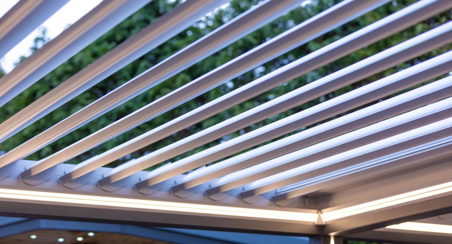 Aluminium louvre roof pergola slats shown open against an evening sky, with integrated lighting